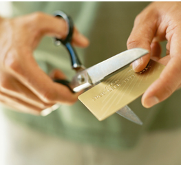 Man cutting up credit card with a pair of scissors